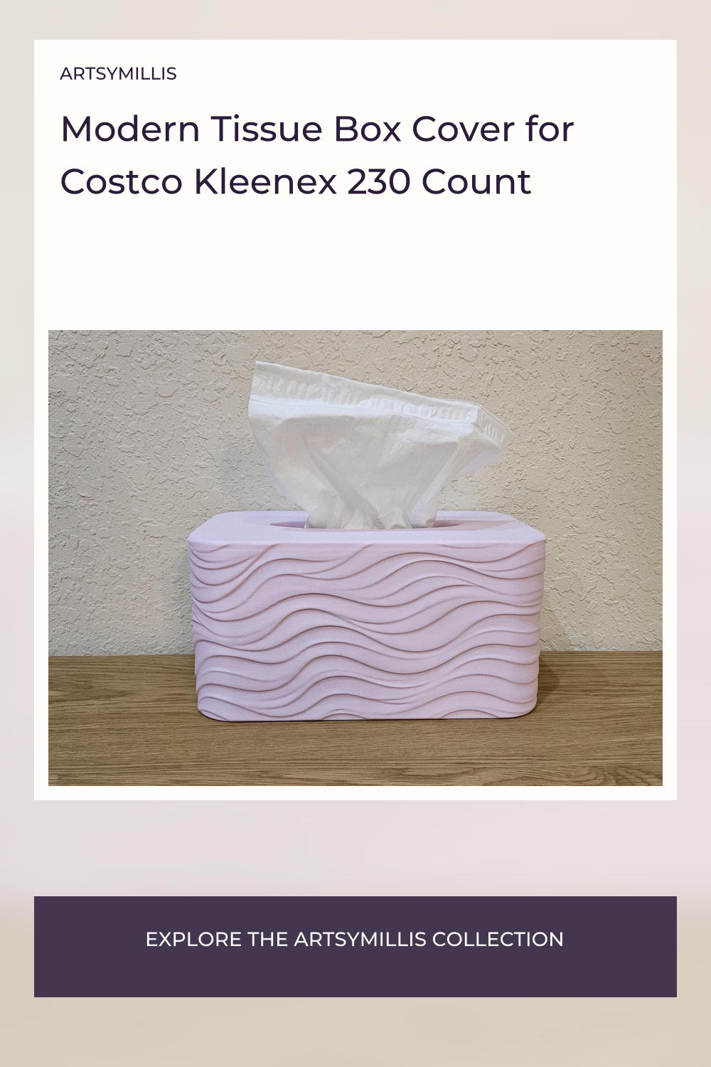 A modern tissue box cover with a wave pattern in a light pink color, placed on a wooden surface against a textured wall.